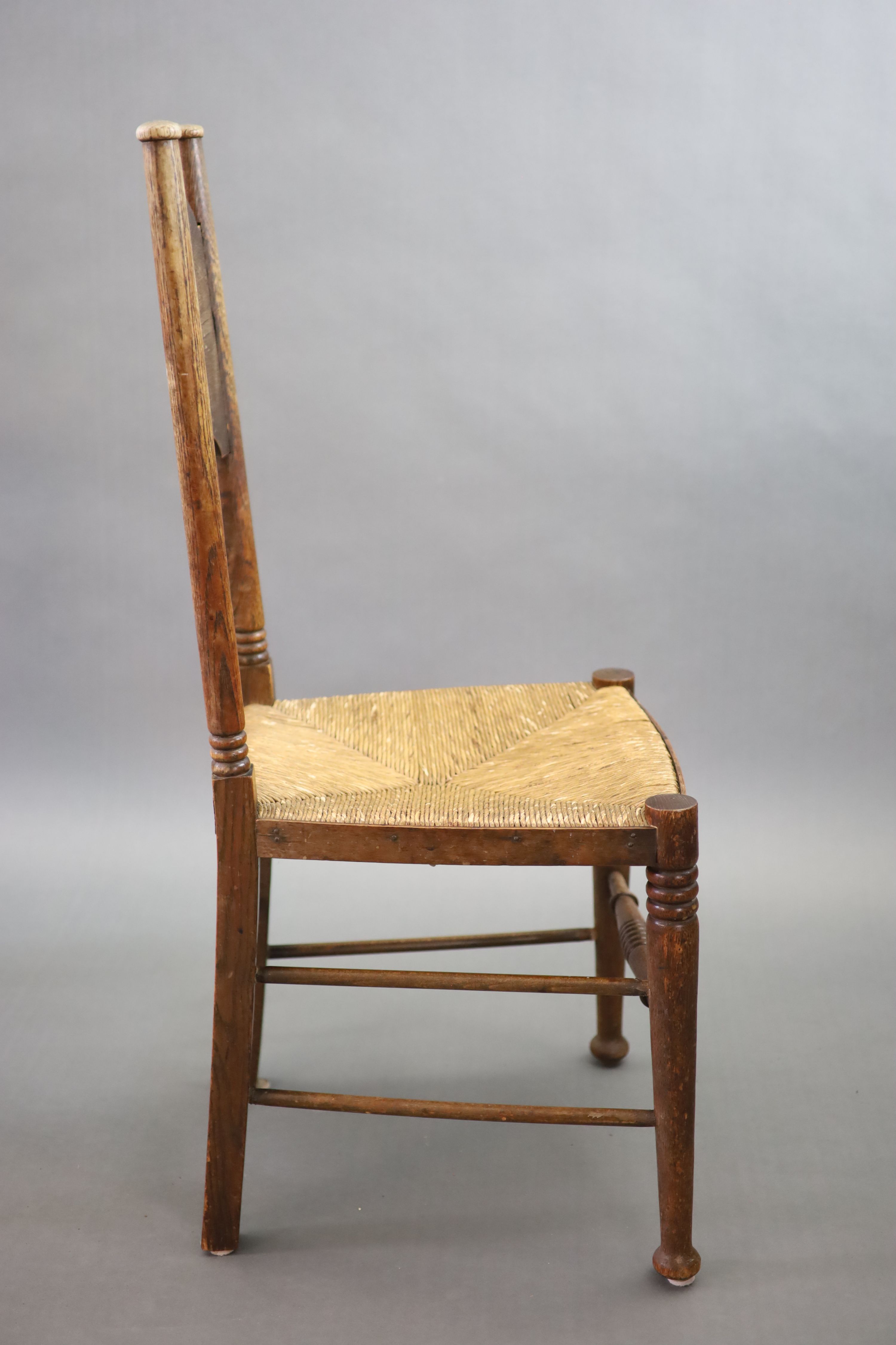 A set of six oak chairs, including a pair of carvers, in the Glasgow School manner by William Birch, High Wycombe, carvers W.58cm D.54cm H.109cm